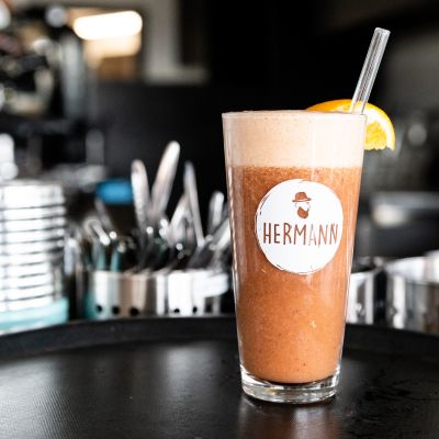 Cocktail mit HERMANN Logo vor der Theke