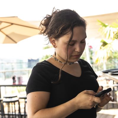 Junge, schwarz gekleidete Kellnerin beim Abrechnen