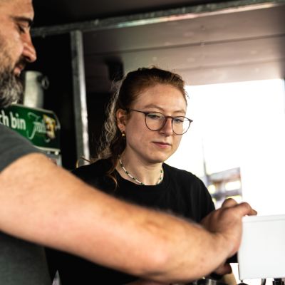 Zwei HERMANN-Mitarbeiter, ein Mann und eine Frau, an der Kaffemaschine