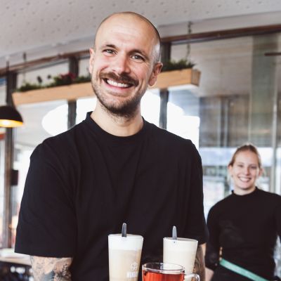 Fröhliche Kellner mit Heißgetränken